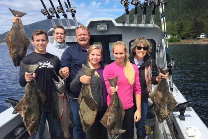 a group of people posing for a photo in front of a fish