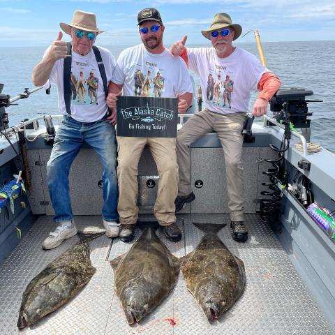 a group of people posing for a photo in front of a fish