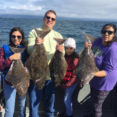 a group of people posing for a photo in front of a fish
