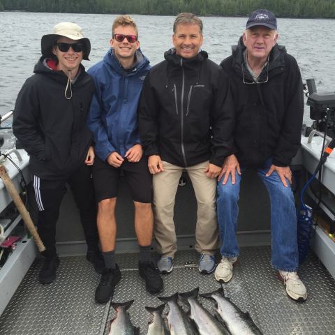 a group of people posing for a photo in front of a fish