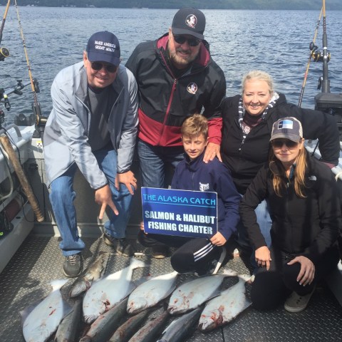 a group of people posing for a photo in front of a fish
