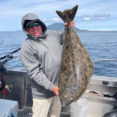 a person holding a fish on a boat in the water