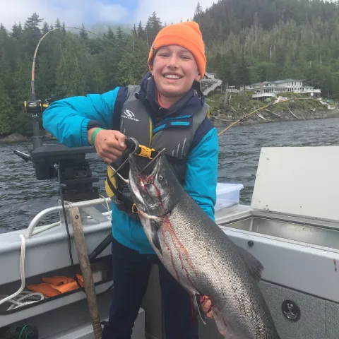 a man holding a fish on a boat